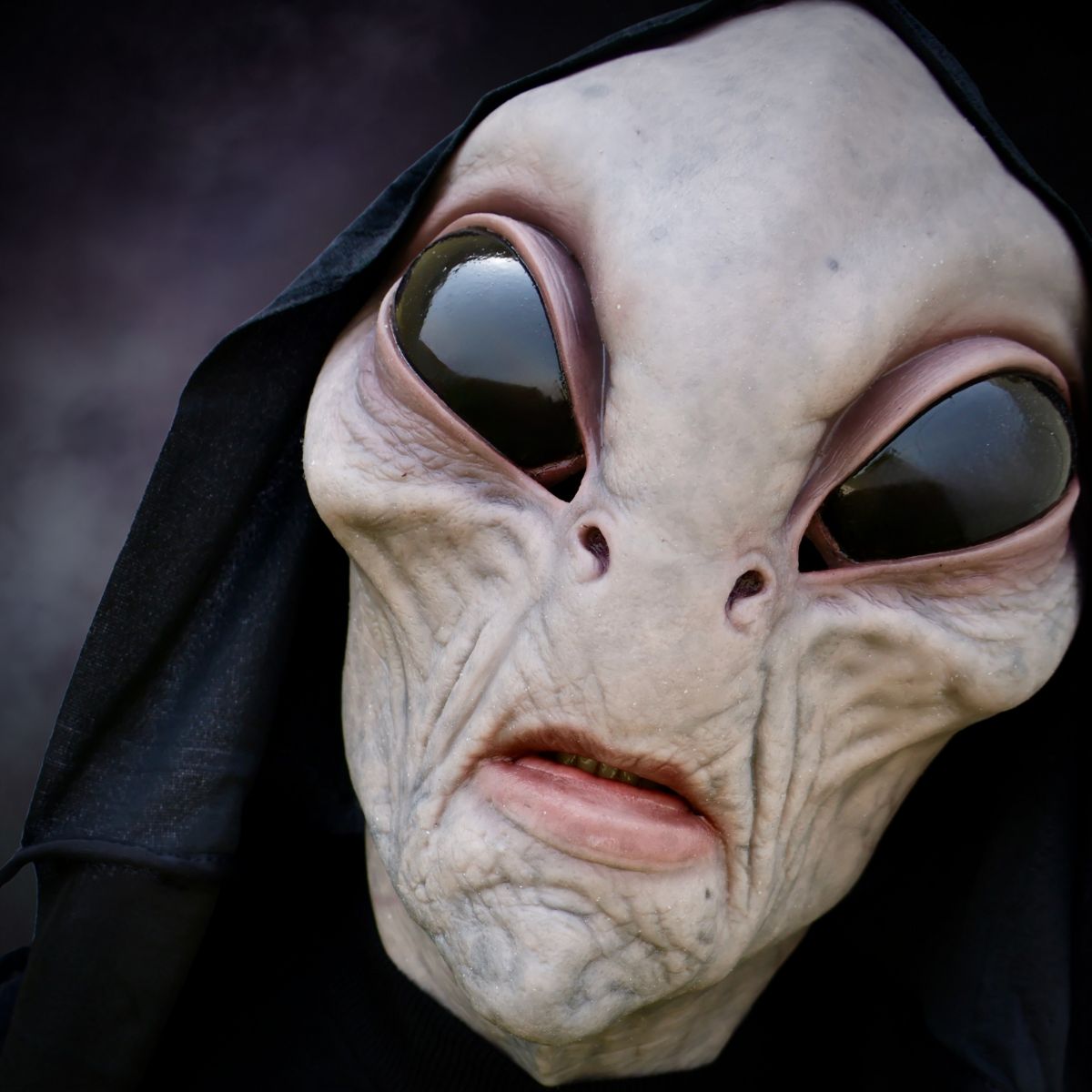 Close-up of alien horror mask with a dark background