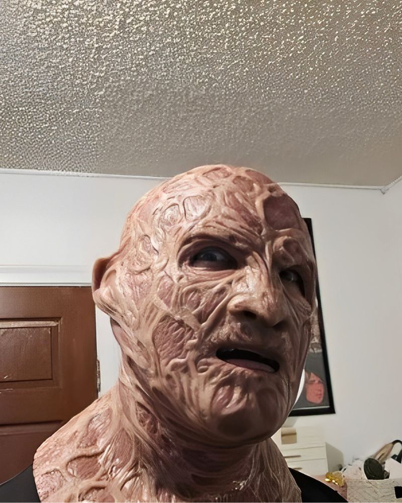 A customer wearing a realistic Freddy Krueger mask indoors during a Halloween party – The Terror Lab