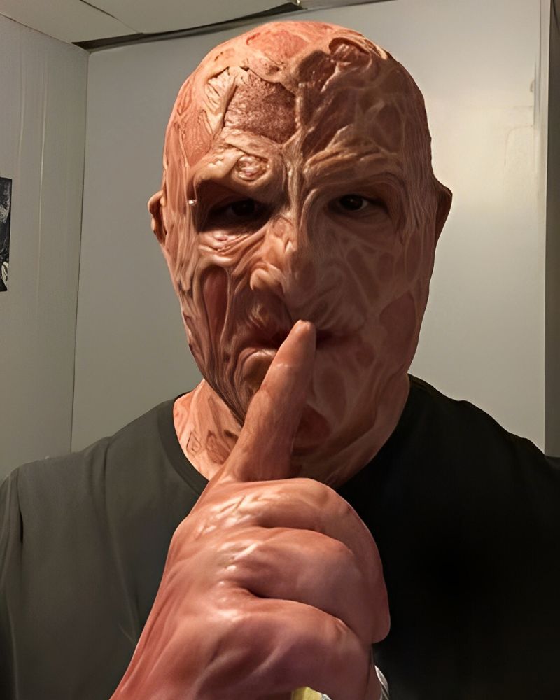 Customer wearing a realistic Freddy Krueger mask making a “shhh” gesture indoors – Halloween season – The Terror Lab