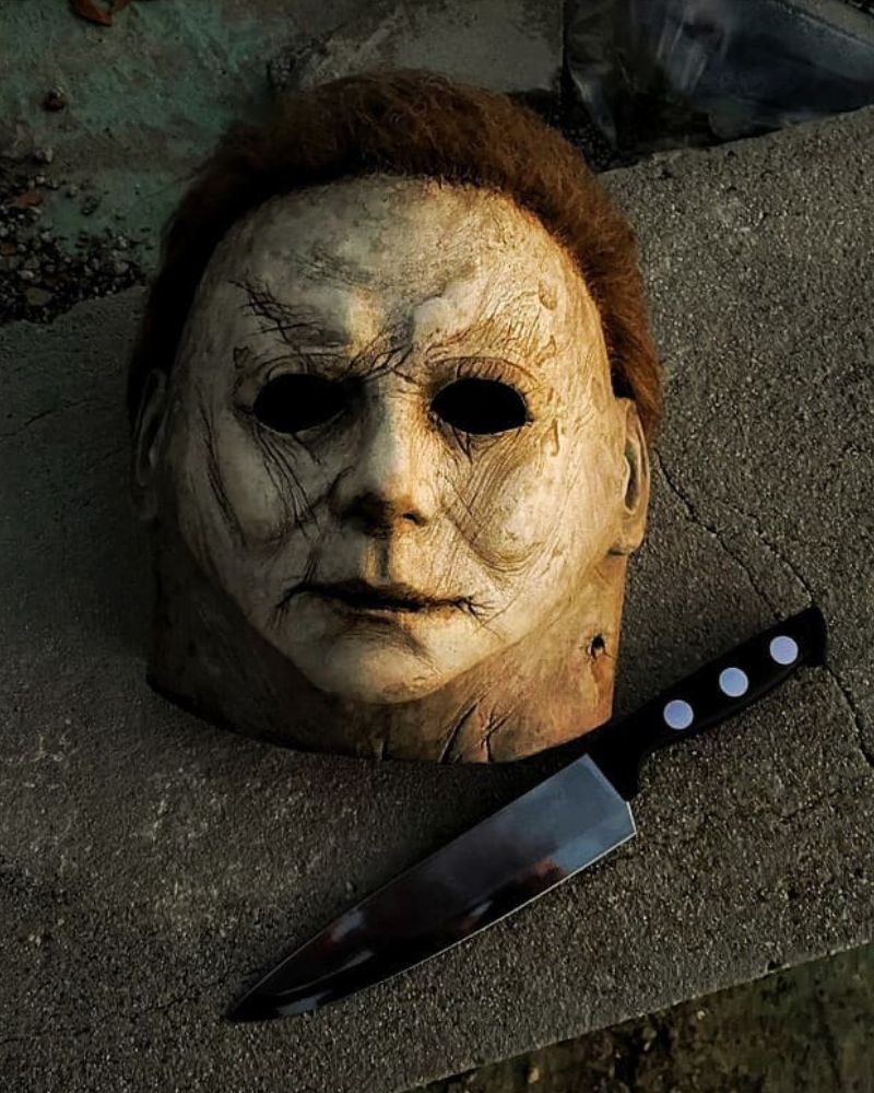 Michael Myers 2018 mask resting on concrete with kitchen knife beside it at dusk, from The Terror Lab.
