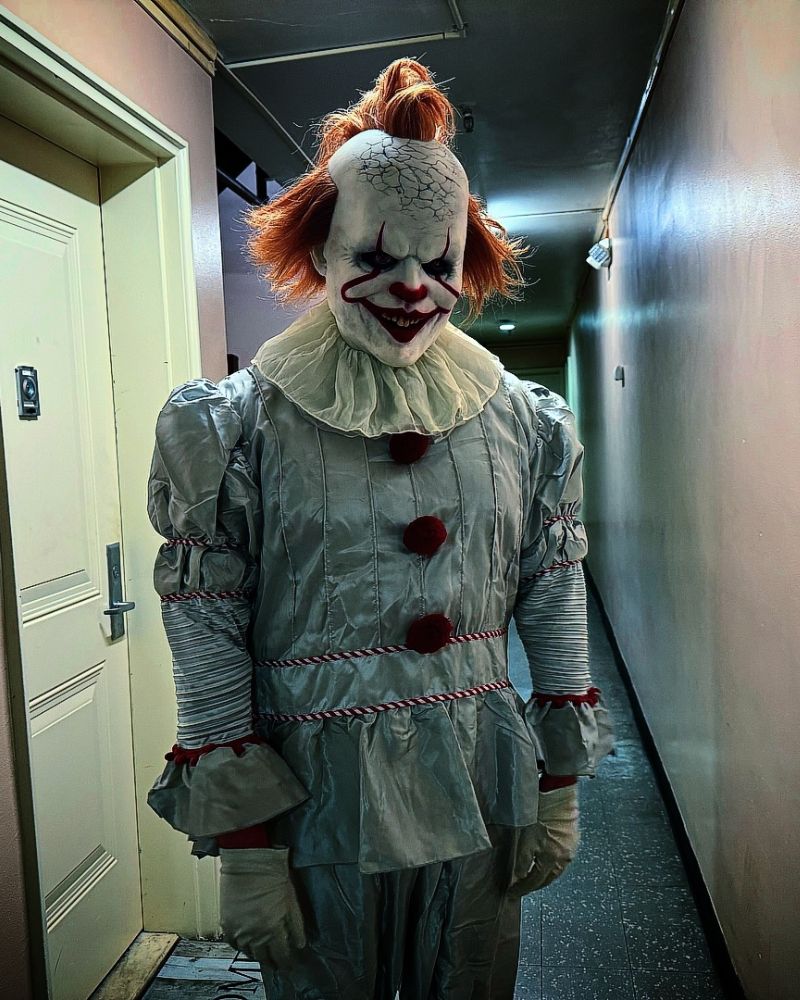 Pennywise clown mask and full costume with cracked skull detail, spotted in an eerie hallway setting — The Terror Lab