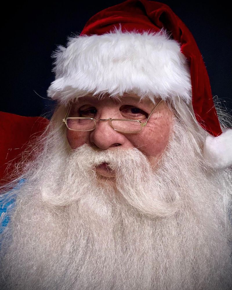 Close-up of the realistic Santa Claus mask and costume, showing the lifelike beard, glasses, and hat during the holiday season — from The Terror Lab