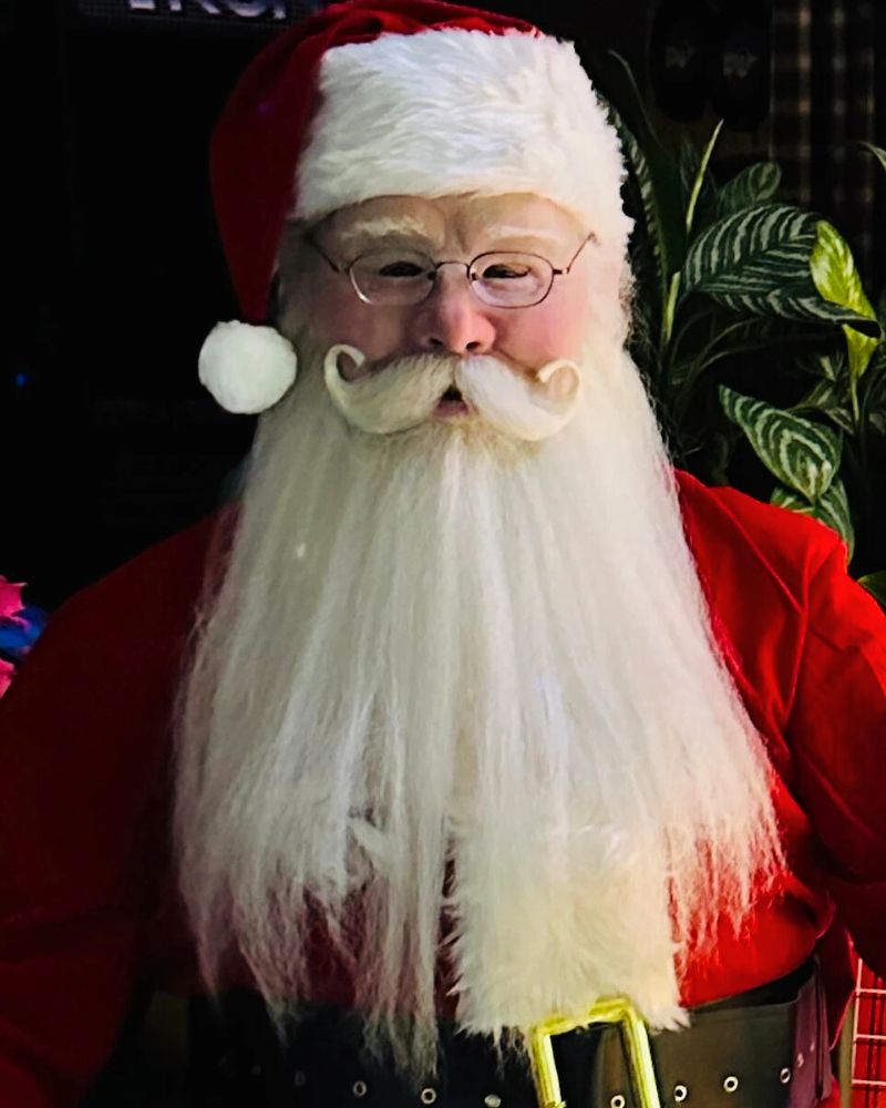 Full Santa Claus costume and realistic mask with curled mustache, red velvet suit, and holiday belt in a festive indoor setting — from The Terror Lab