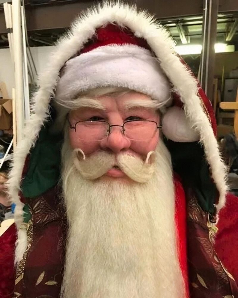 Santa Claus realistic mask and deluxe holiday costume with red and gold hooded cape, curly mustache, and wireframe glasses — The Terror Lab.