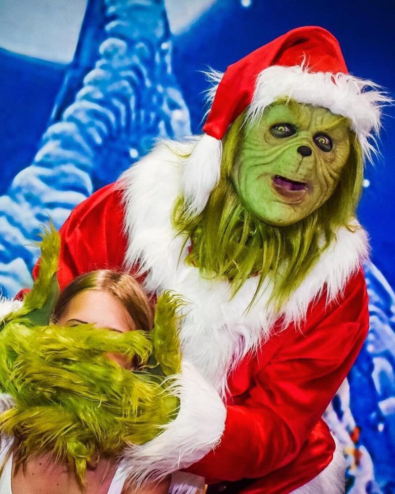 Stealer of Christmas mask and costume in Santa suit playfully covering guest's face during a Halloween and Christmas event — The Terror Lab