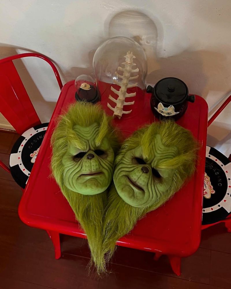 The Stealer of Christmas realistic masks displayed on a red table with spine decor, perfect for Halloween and Christmas transformations — The Terror Lab.