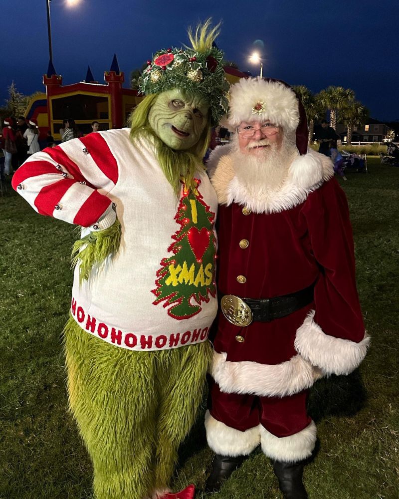 The Stealer of Christmas realistic mask and full costume spotted at a holiday party next to Santa Claus, featuring green fur and a festive sweater — The Terror Lab
