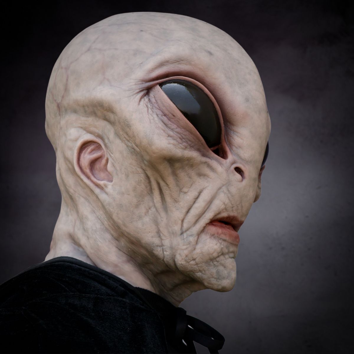 Close-up of an alien mask horror creature with a dark background