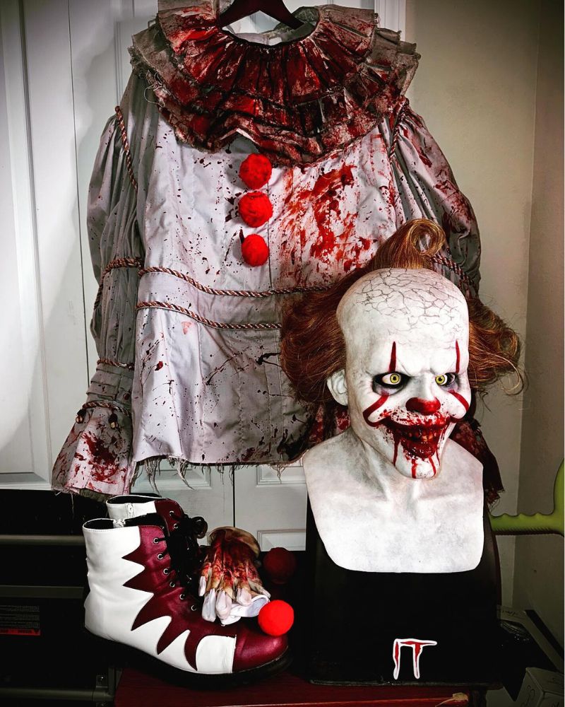 Full Pennywise costume with blood-stained details, mask bust, gloves, and clown shoes on display — The Terror Lab